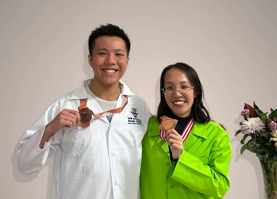 Jason and his sister Manjeka holding their International Biology Olympiad Bronze Medals